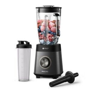 Blender Philips avec gobelet de 1,5 L et accessoires noir argenté, rempli de fruits rouges et légumes, sur fond blanc.